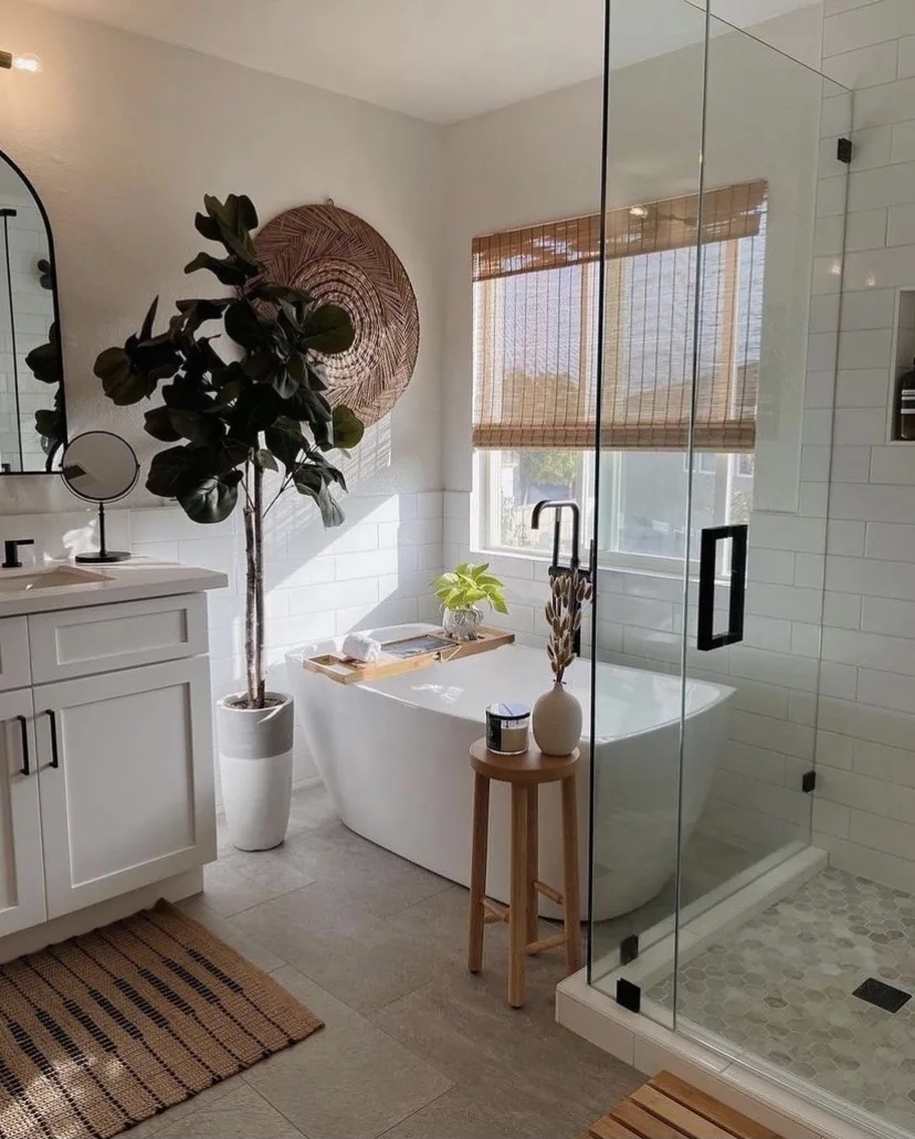 A bright bathroom with a freestanding tub, white subway tile and a walk-in glass shower
